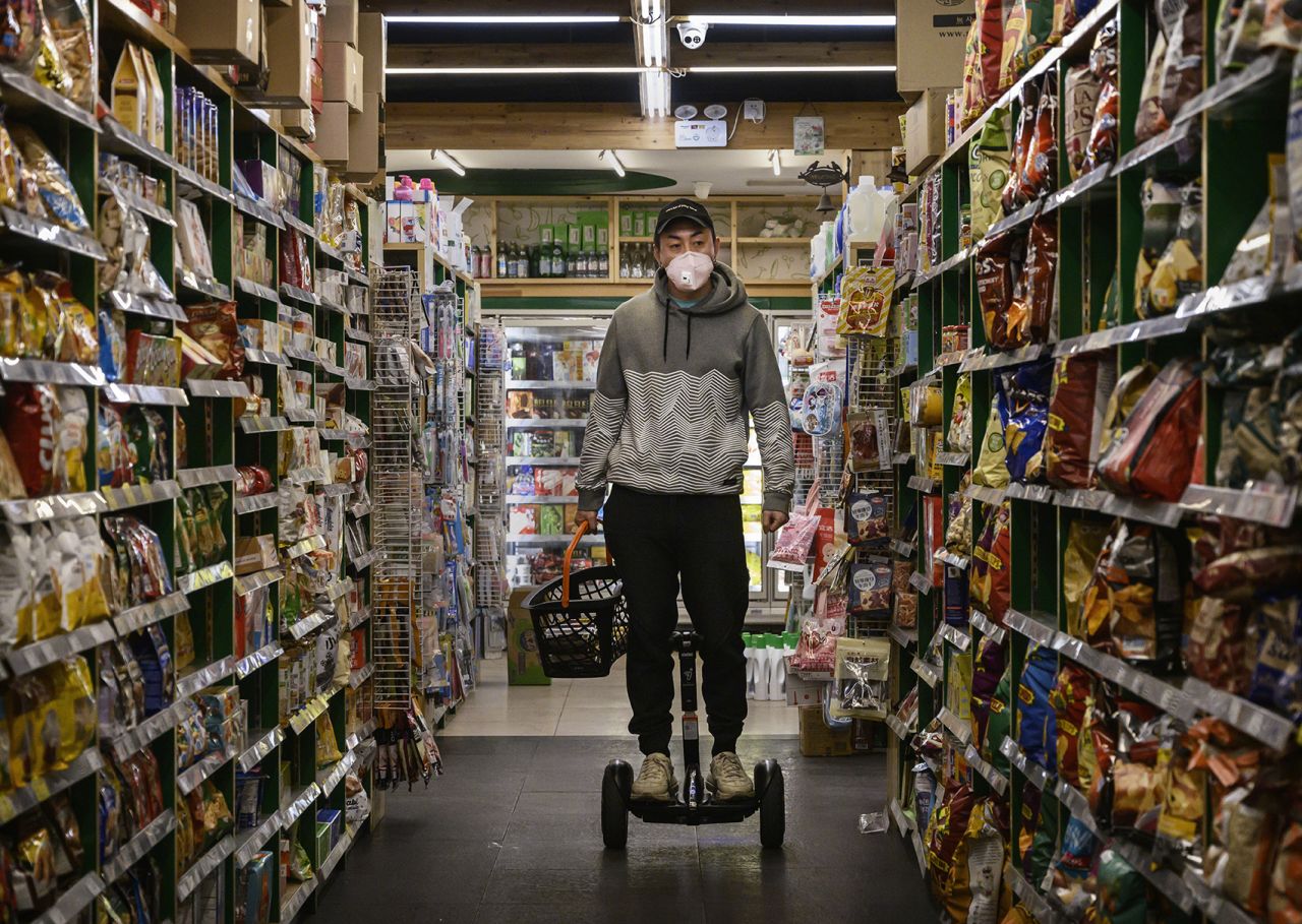 A man wears a protective mask as he rides a segway in a grocery store while shopping on February 11 in Beijing.