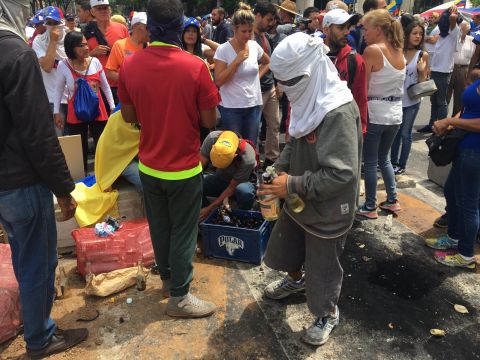 A protester makes Molotov cocktails.