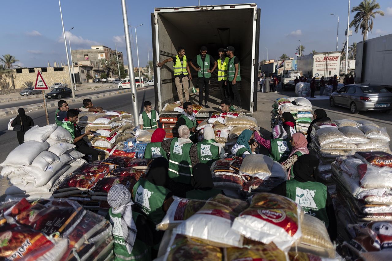 Volunteers load food and supplies onto trucks in an aid convoy for Gaza on October 16, in North Sinai, Egypt.