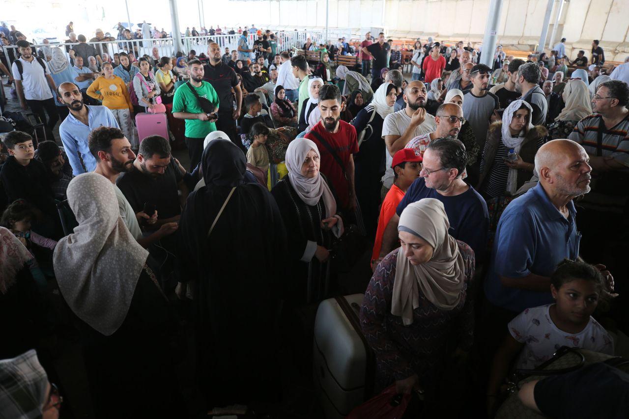 People sit in the waiting area at the Rafah border crossing in southern Gaza before crossing into Egypt on November 1. 