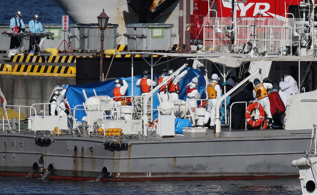 Workers transfer a person from the Diamond Princess cruise ship onto a Coast Guard boat in Yokohama on February 5, 2020.