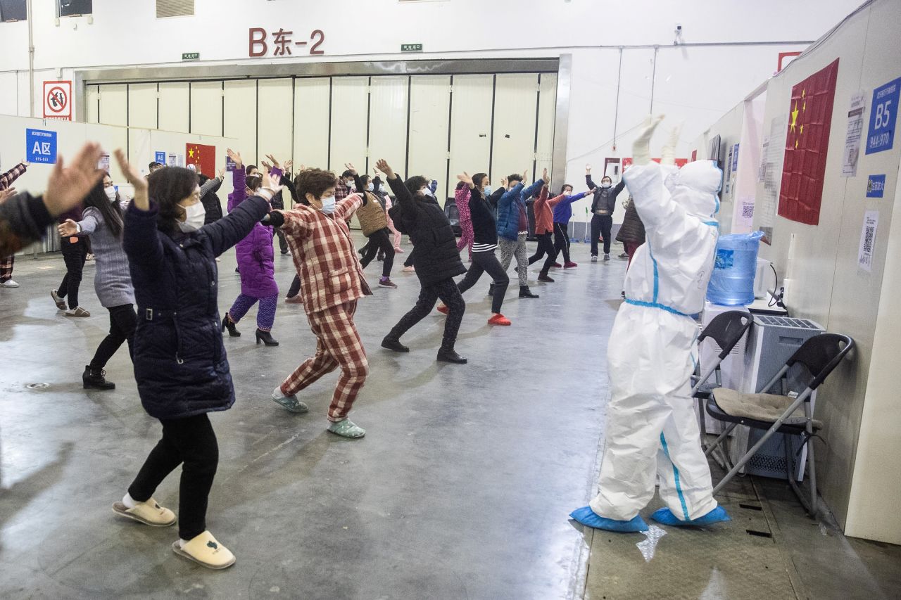 A member of the medical staff leads patients who have displayed mild symptoms of the novel coronavirus in group exercises.