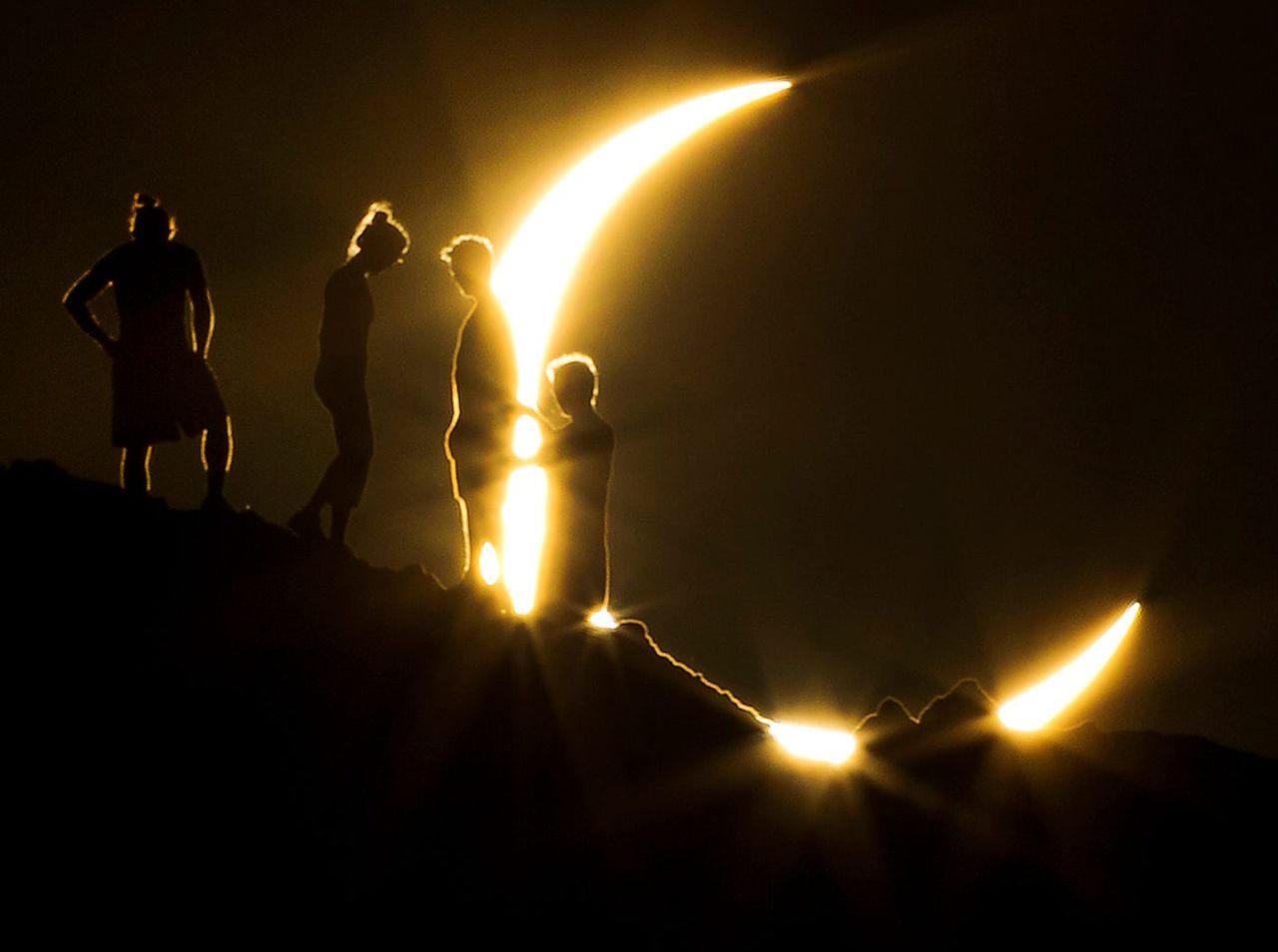 Hikers watch a partial solar eclipse from Papago Park in Phoenix, on May 20, 2012.