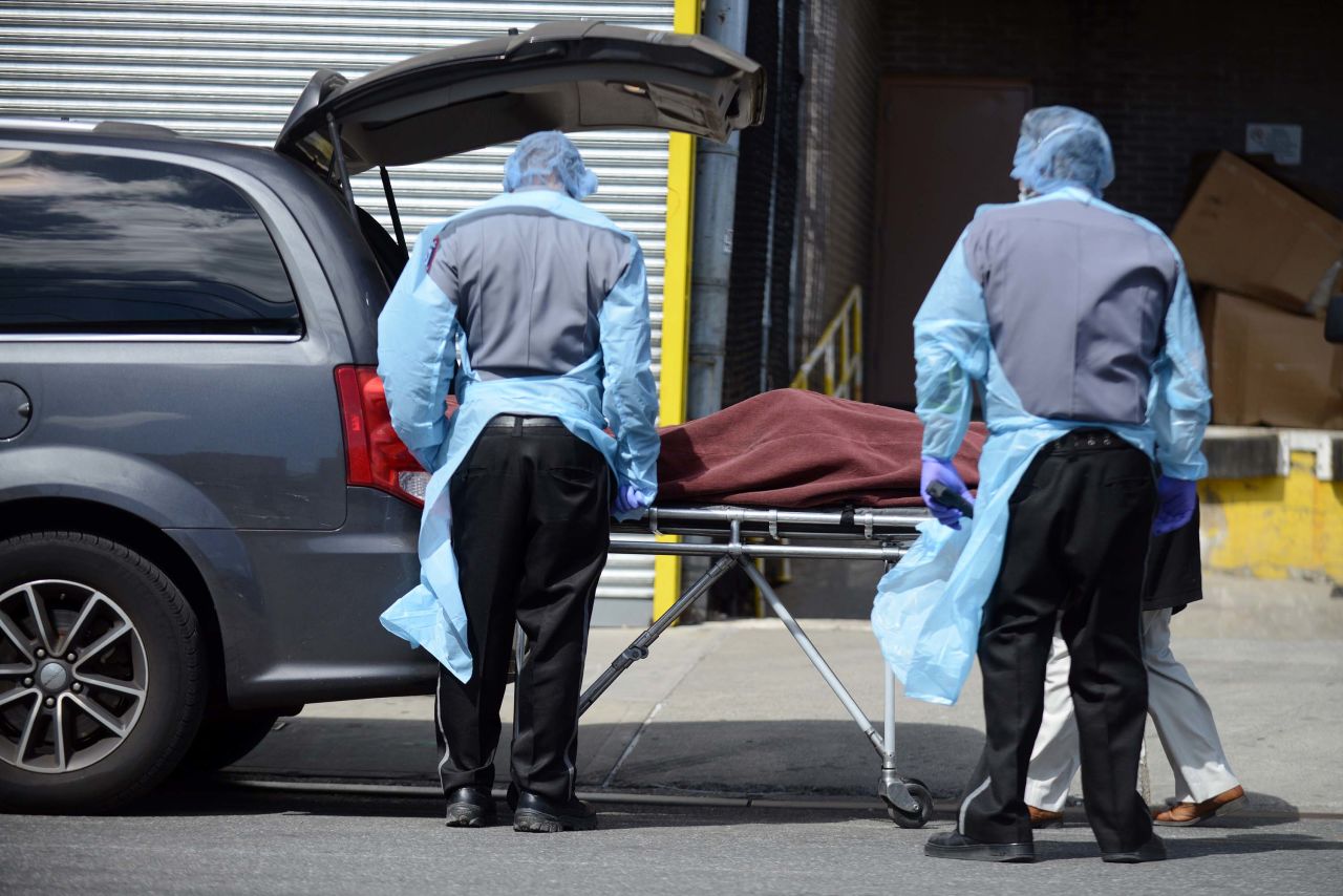 A deceased coronavirus patient is loaded into a waiting funeral home van outside Wyckoff Heights hospital in Brooklyn, New York, on April 2.