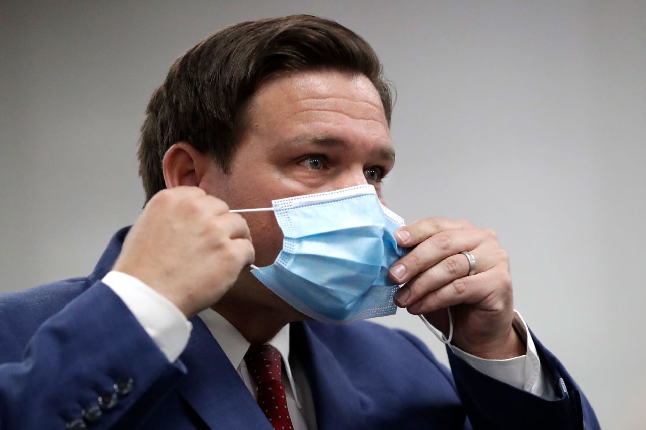 Florida Gov. Ron DeSantis puts on his face mask at a news conference at Jackson Memorial Hospital on July 13 in Miami, Florida. 