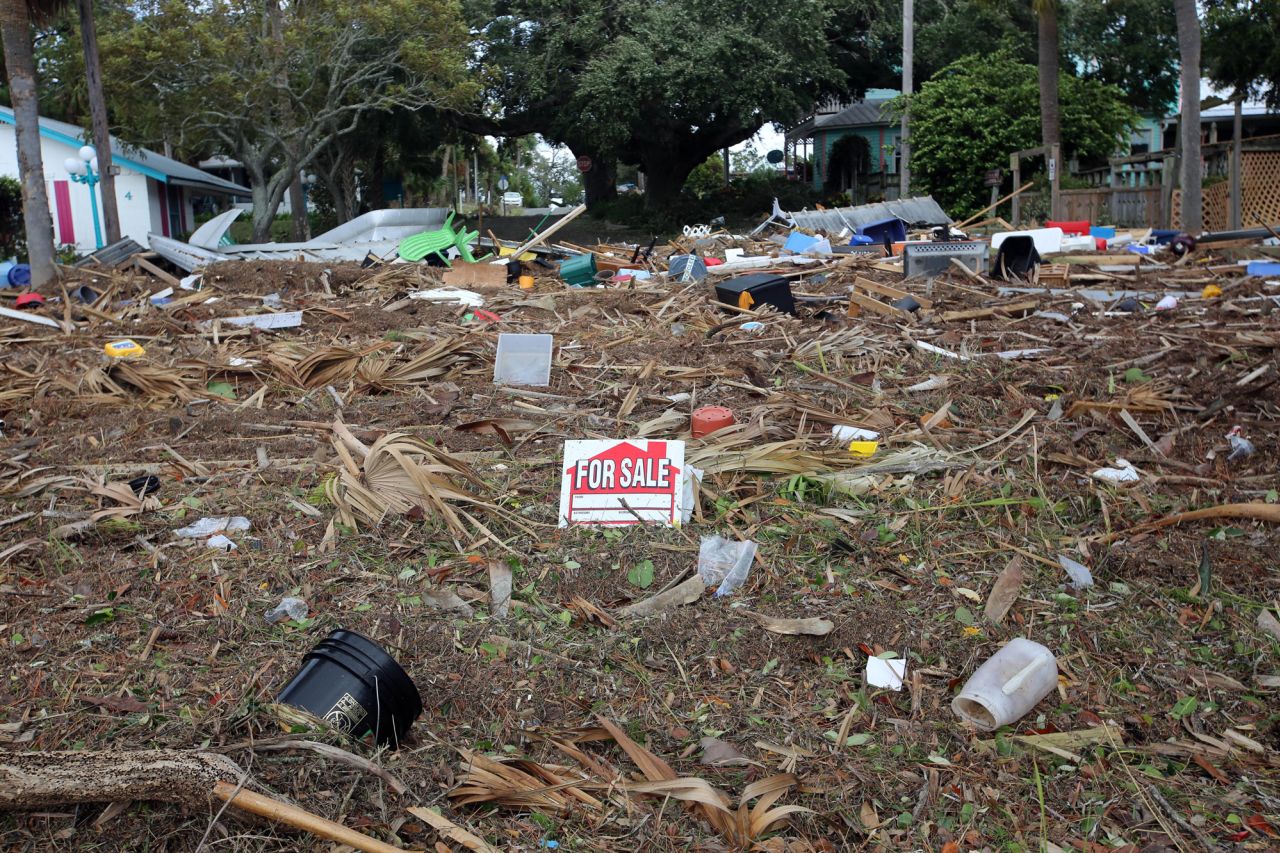 A For Sale sign stands in the middle of a debris pile in Cedar Key, Florida, on August 30, 2023.