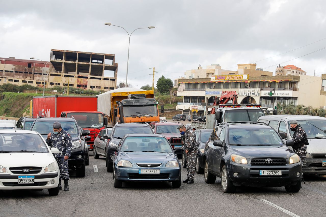 Members of the Lebanese security forces check citizens' documents at a COVID-19 checkpoint near the coastal town of Safra on the Tripoli-Beirut main highway on January 19, 2021.