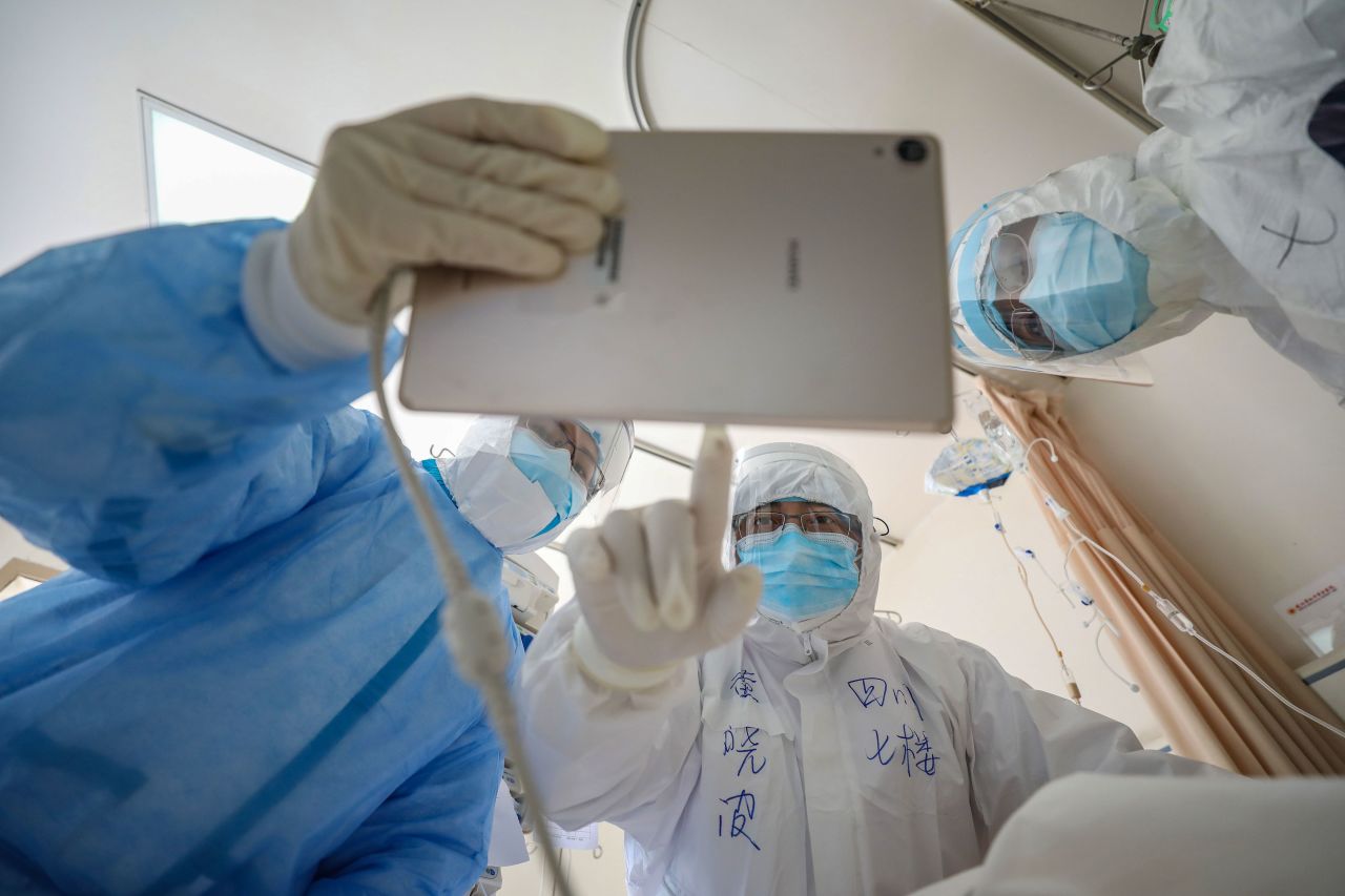 A doctor looks at an image as he checks a patient who is infected by the COVID-19 coronavirus at the Wuhan Red Cross Hospital in Wuhan in China's central Hubei province.