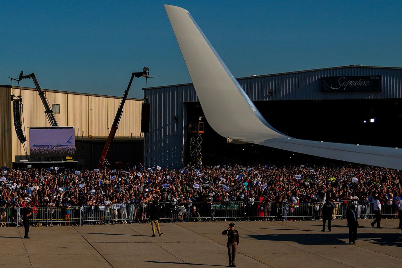 A crowd watches as Air Force Two, carrying Democratic presidential nominee Vice President Kamala Harris and her running mate Minnesota Gov. Tim Walz, lands for a campaign rally at Detroit Metropolitan Wayne County Airport on August 7.