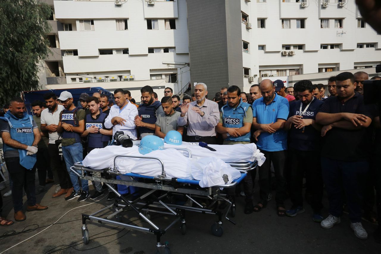 Relatives and colleagues of Palestinian journalists Saeed Al-Taweel and Mohammad Sobh, who were killed in Israeli airstrikes, perform funeral prayer in Gaza on October 10.