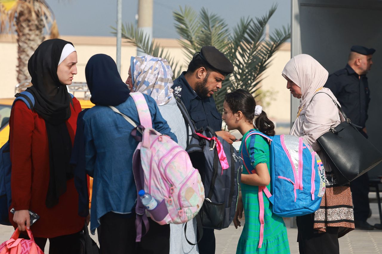 People show their documents on the Palestinian side of the Rafah border crossing on November 13 before crossing to the Egyptian side.