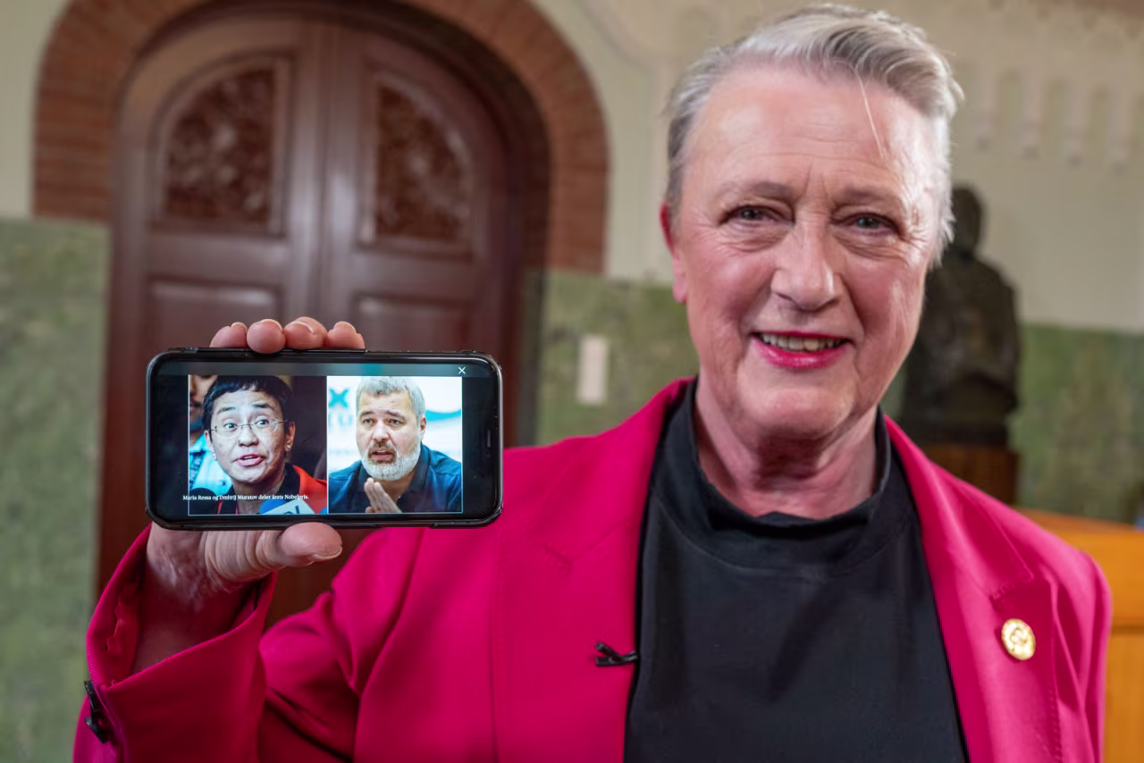 Berit Reiss-Andersen, chair of the Nobel Peace Prize Committee, presents a mobile phone displaying photos of journalists Maria Ressa and Dmitry Muratov following a press conference to announce the winners of the 2021 Nobel Peace Prize.