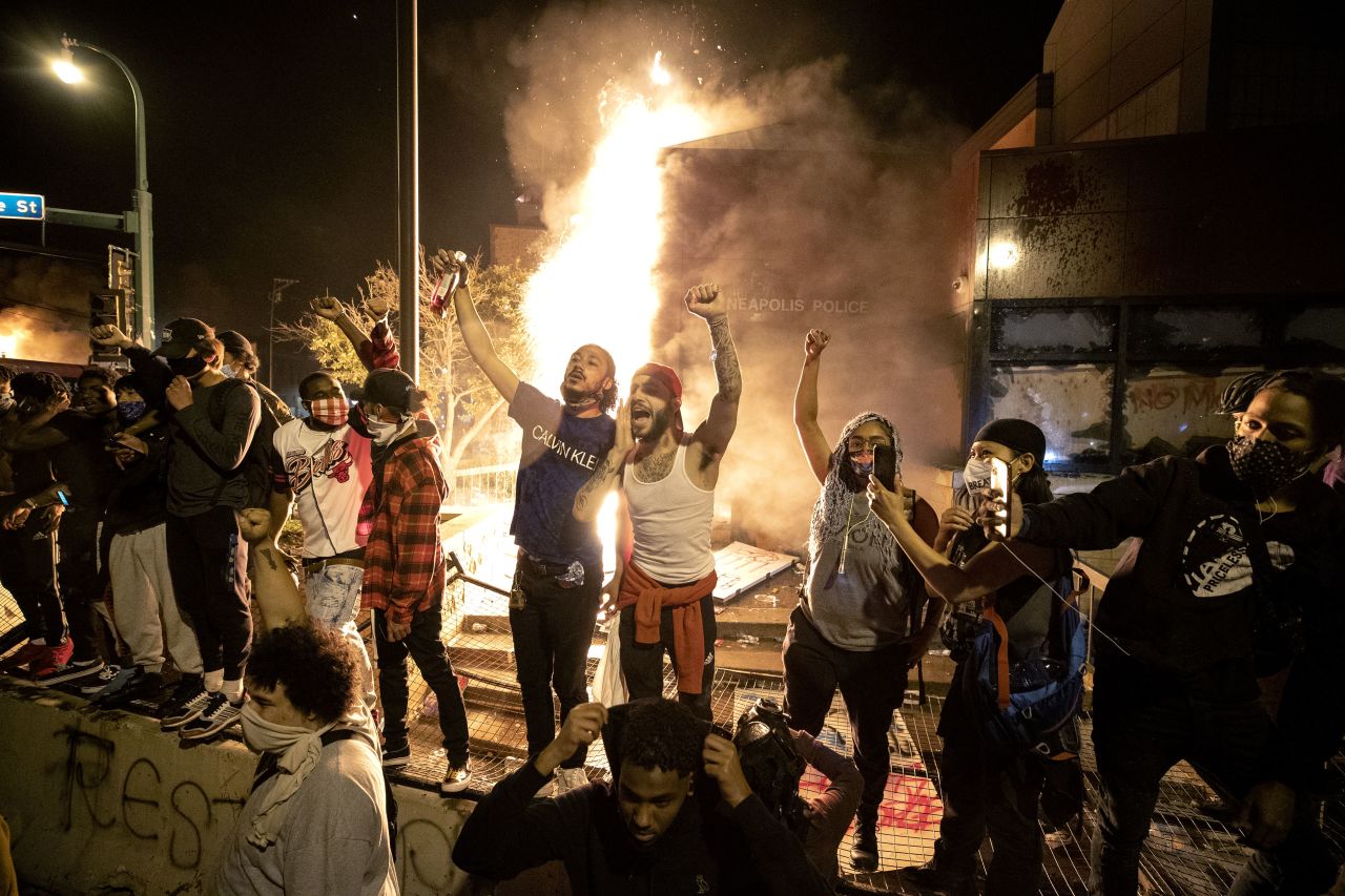 People stand outside the Minneapolis Police 3rd Precinct in Minnesota after fires were set at the building during protests on May 28.