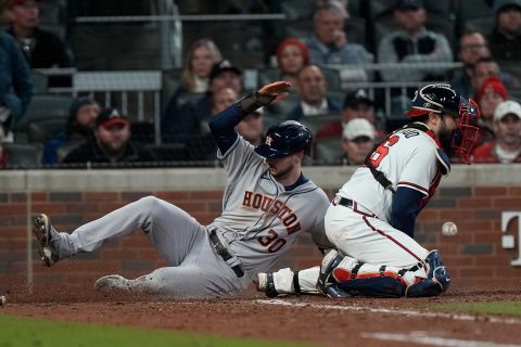 Astros' Kyle Tucker scores past Braves catcher Travis d'Arnaud on a single by Martin Maldonado during the seventh inning.