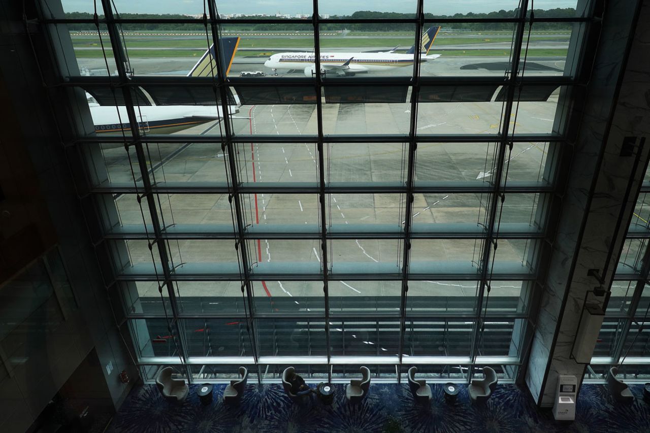 A traveler wearing a protective mask waits at the transit area of Changi International Airport terminal on Dec. 15 in Singapore. 