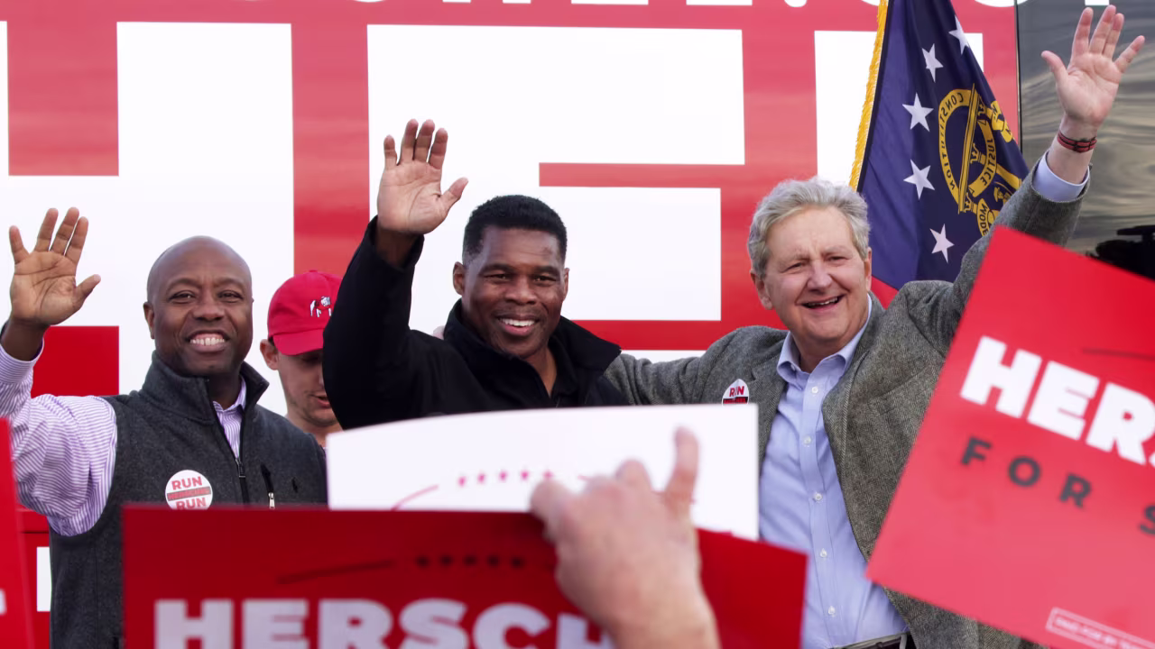 US Sens. Tim Scott, left, and John Kennedy, right, join Herschel Walker at a campaign event in Loganville, Georgia, on Sunday.
