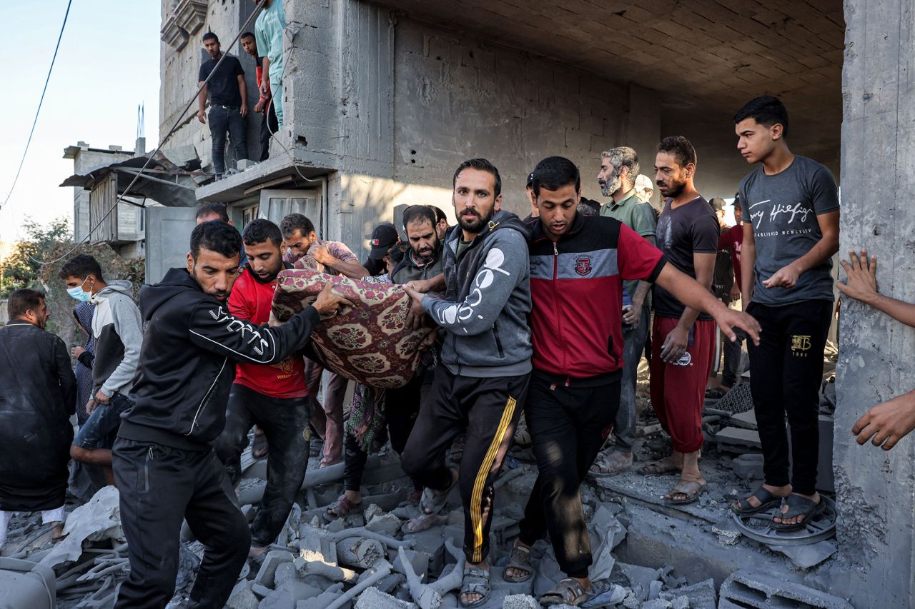 People carry the body of a victim killed during an Israeli bombardment in Rafah, southern Gaza, on October 19.