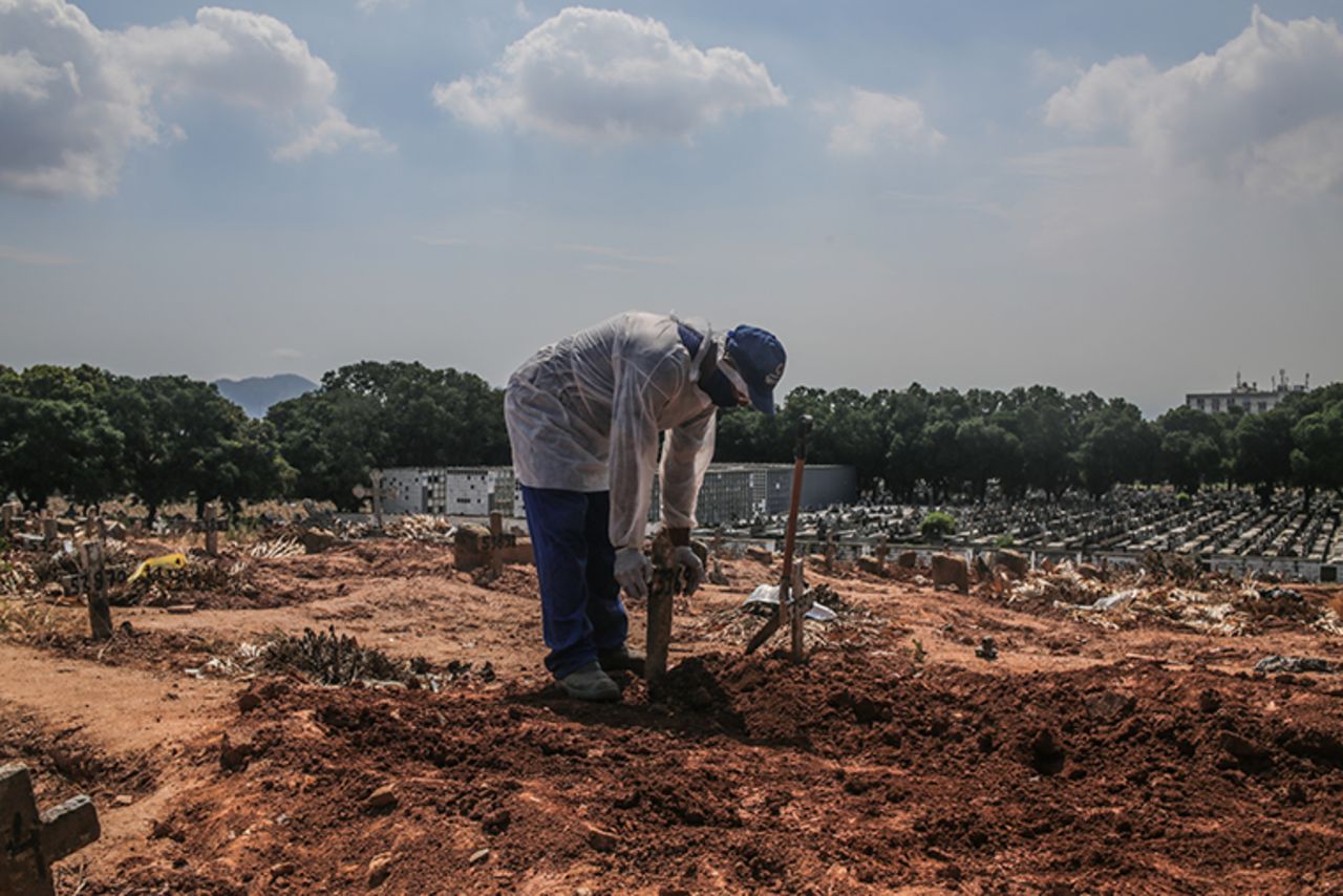 A gravedigger puts a cross over a grave at the Sao Francisco Xavier cemetery on December 16, 2020 in Rio de Janeiro, Brazil. 