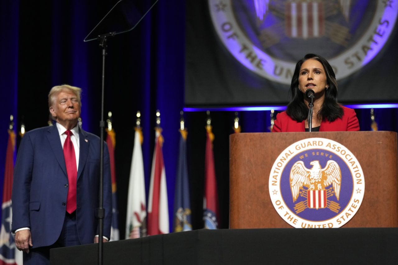 Donald Trump looks on as former Rep. Tulsi Gabbard speaks at the National Guard Association of the United States General Conference on Monday in Detroit.