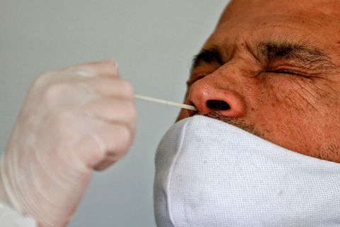 A health worker collects a nasal swab sample from a man to be tested for COVID-19 in Santiago, Chile, on Friday, July 10.