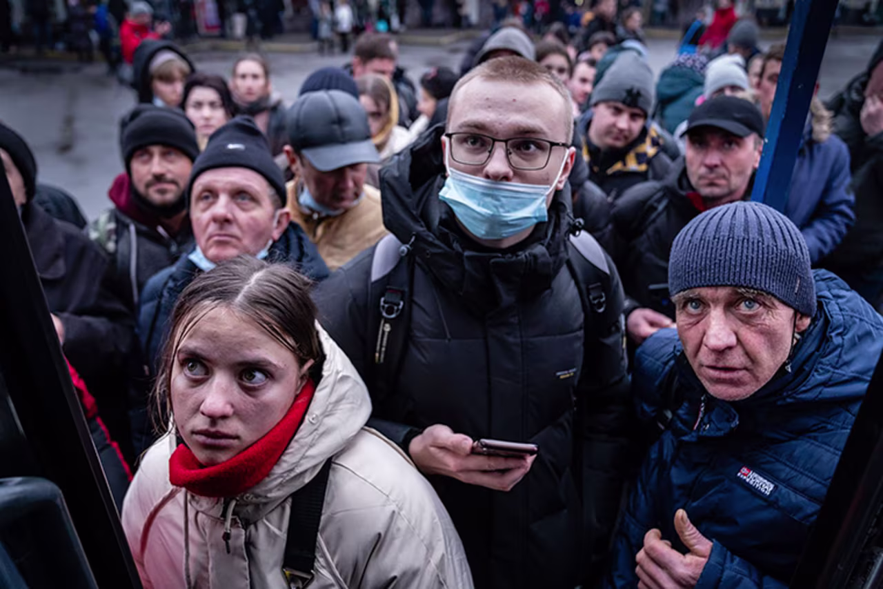 People in Kyiv try to board a bus to travel west toward Poland on Thursday.