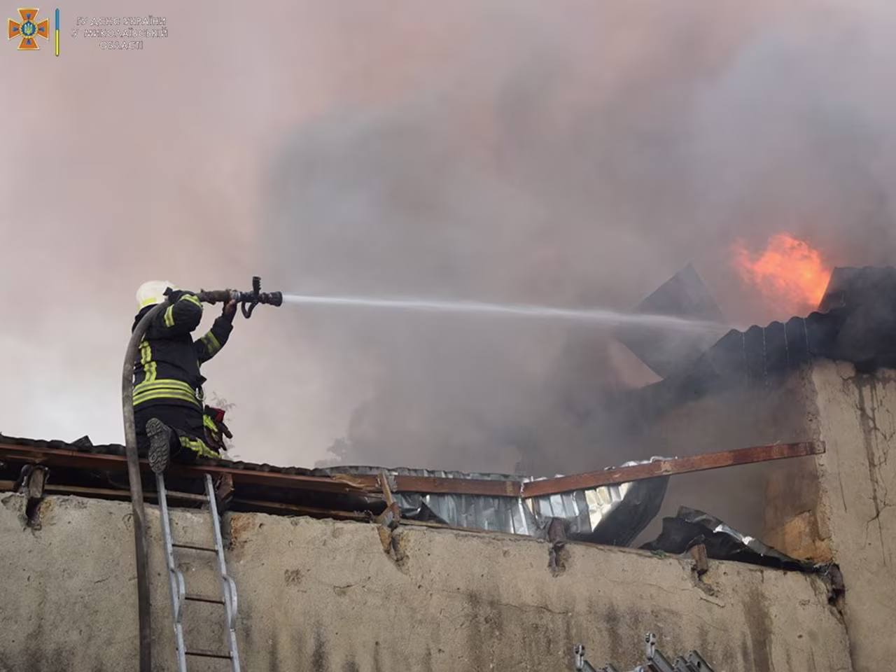A firefighter works to douse a fire in a building in Mykolaiv, Ukraine, in this handout picture released on July 31.