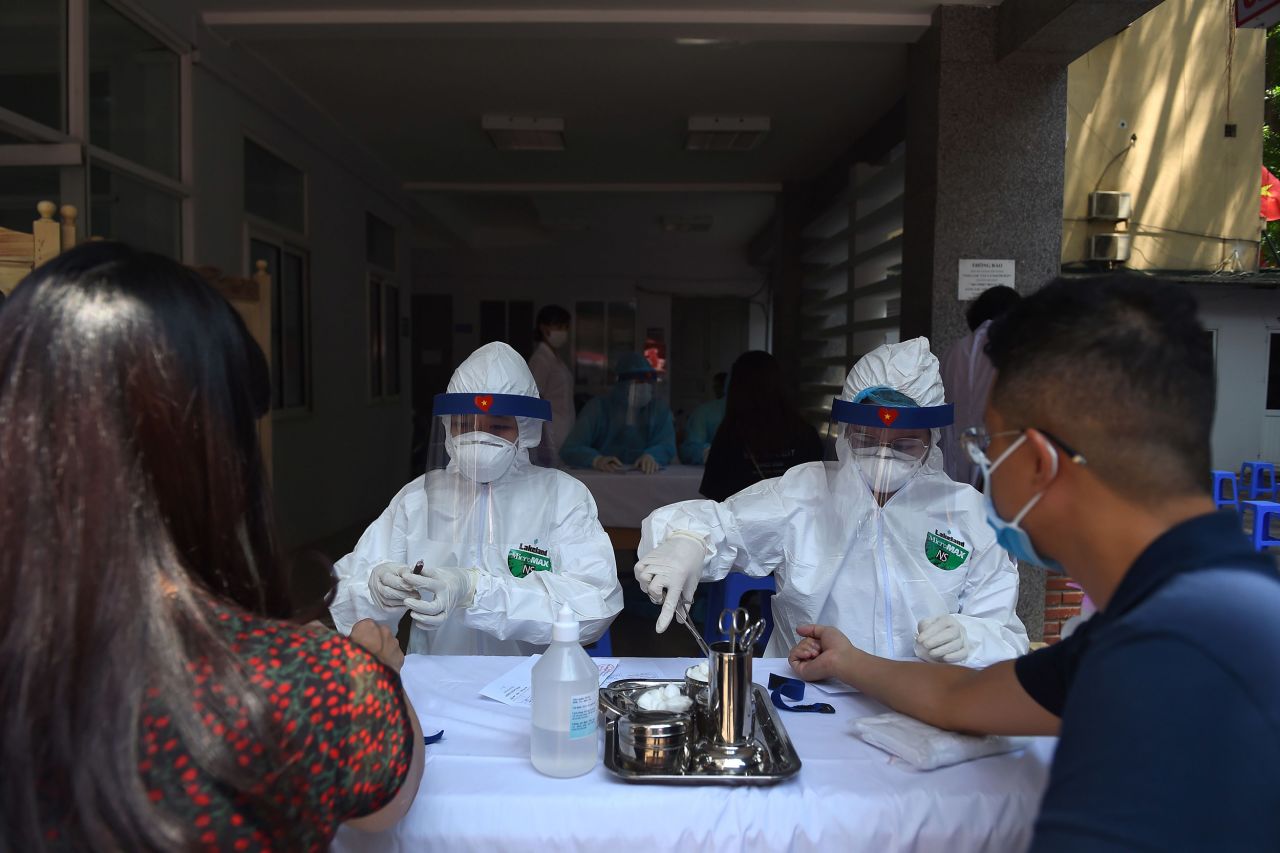 Residents get blood samples taken by health workers at a Covid-19 rapid testing site in Hanoi, Vietnam, on July 30. 