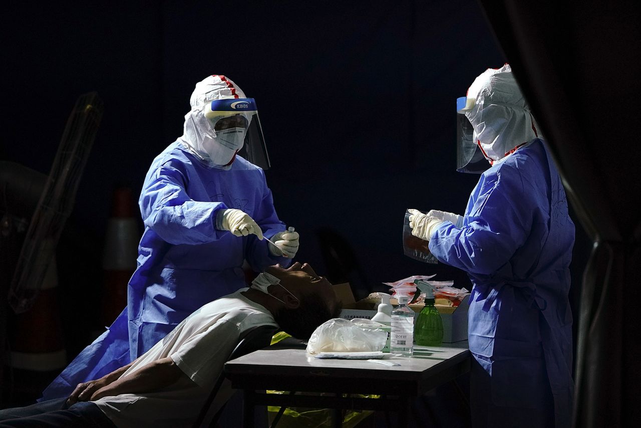 A nurse wearing a protective suit and mask takes a nucleic acid test for Covid-19 at a testing facility on June 17, in Beijing, China. 