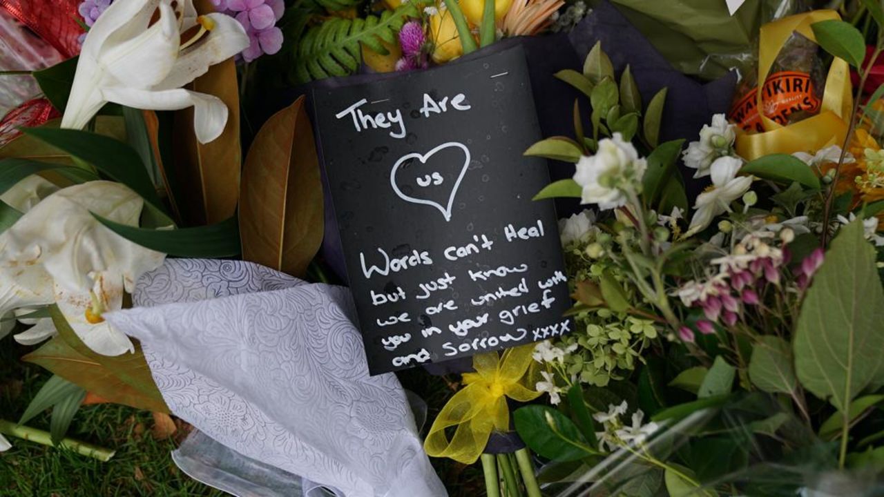 A note laid beside flowers is seen outside the Christchurch Botanic Gardens.