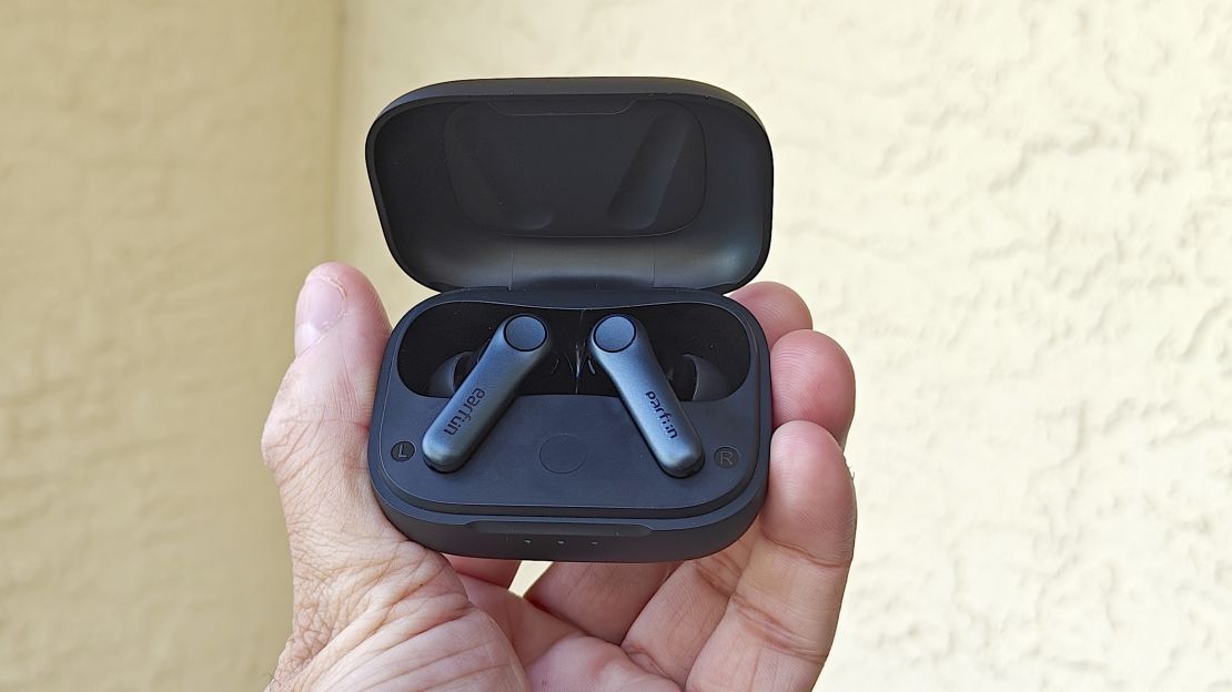 Hand holding up EarFun Air Pro 4 with the case open.