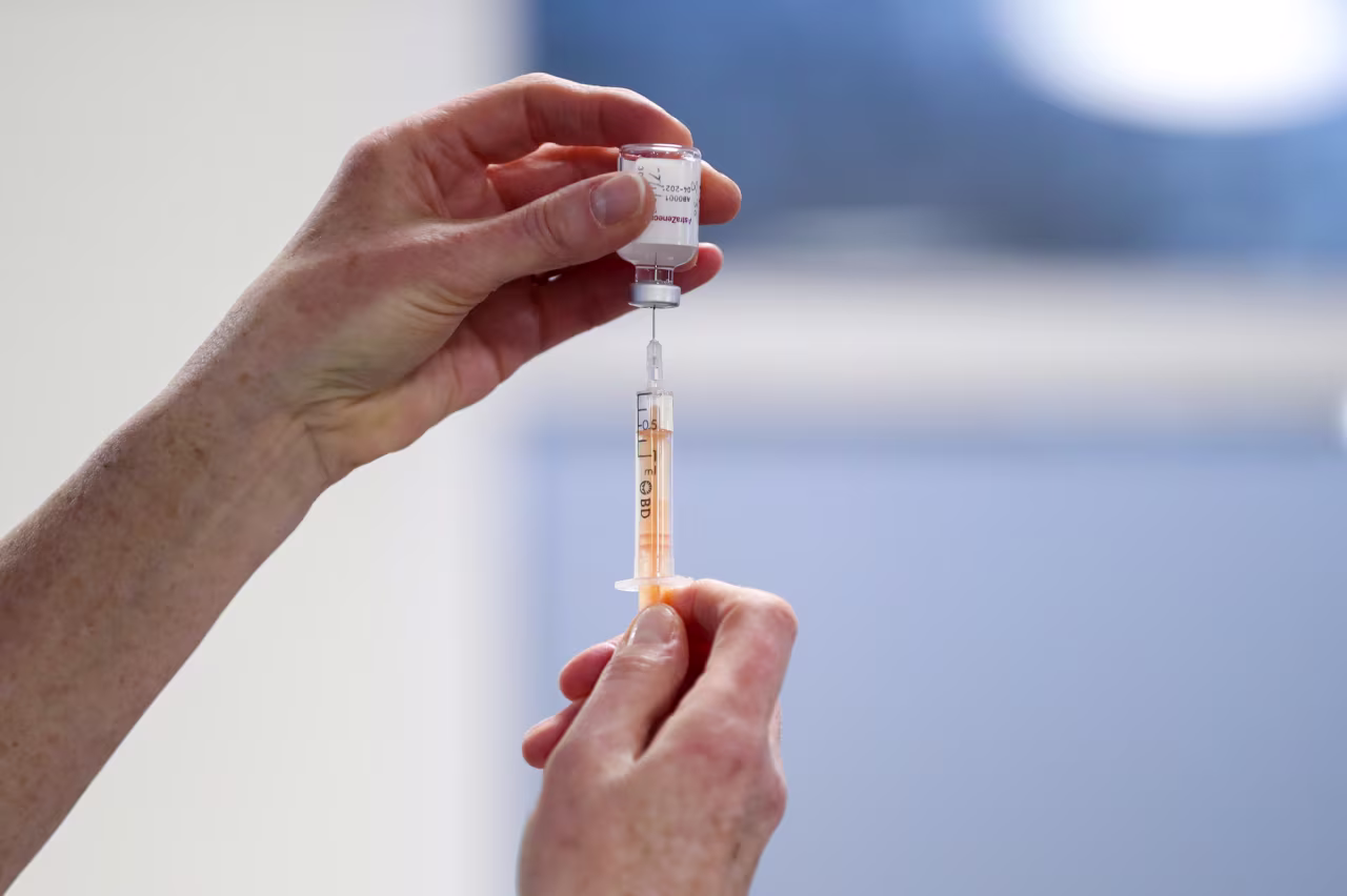A health care worker fills a syringe with a dose of AstraZeneca coronavirus vaccine at the Pentland Medical Practice on January 7 in Currie, Scotland. 