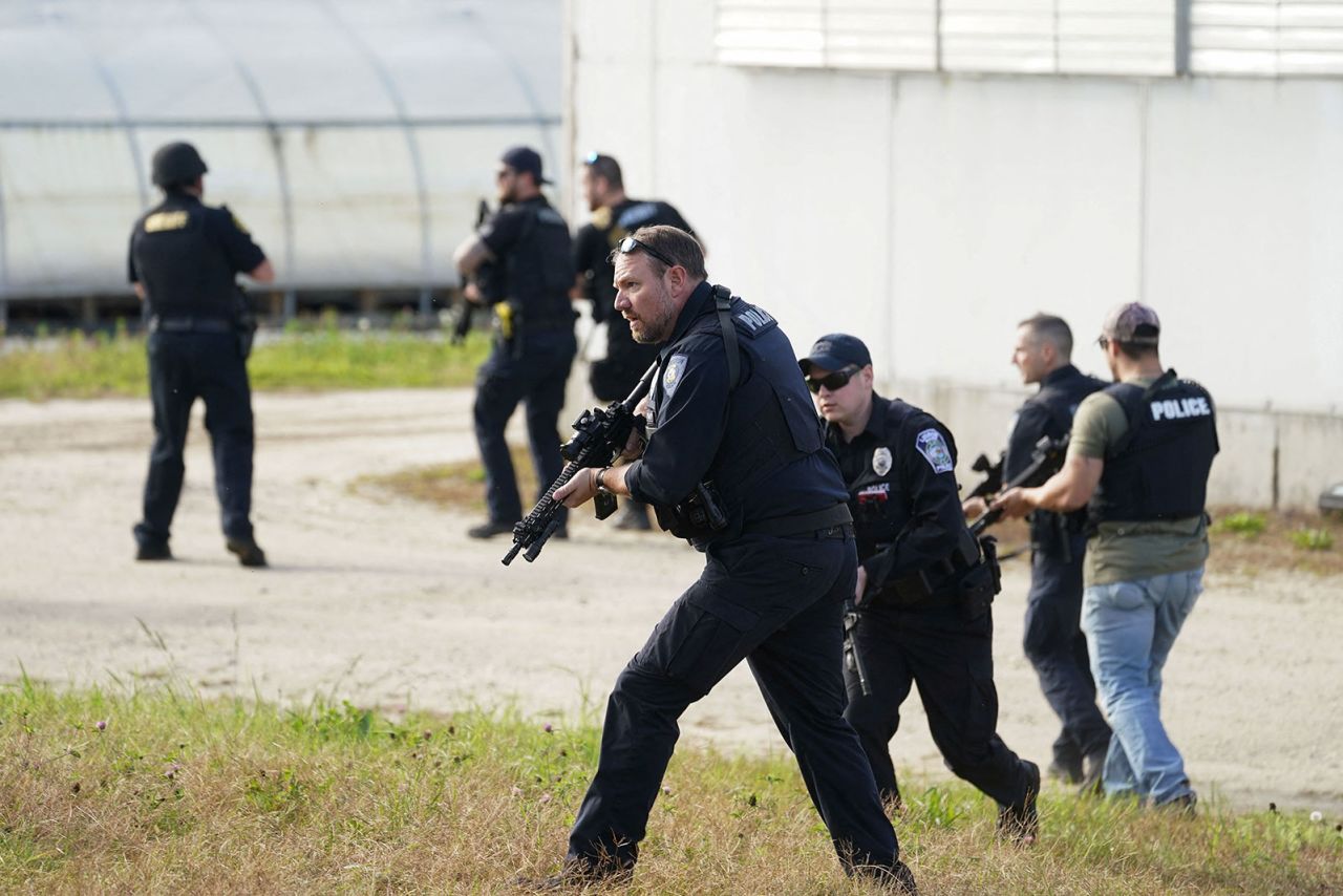 Members of law enforcement search a farm in Lisbon Falls, Maine, on Friday. 