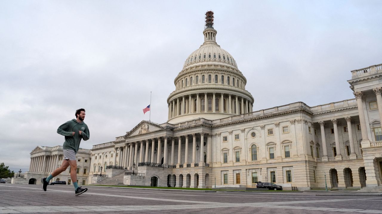 A jogger runs by the US Capitol as the deadline to avert a partial government shutdown approaches at the end of the day on Capitol Hill in Washington, DC, on Saturday. 