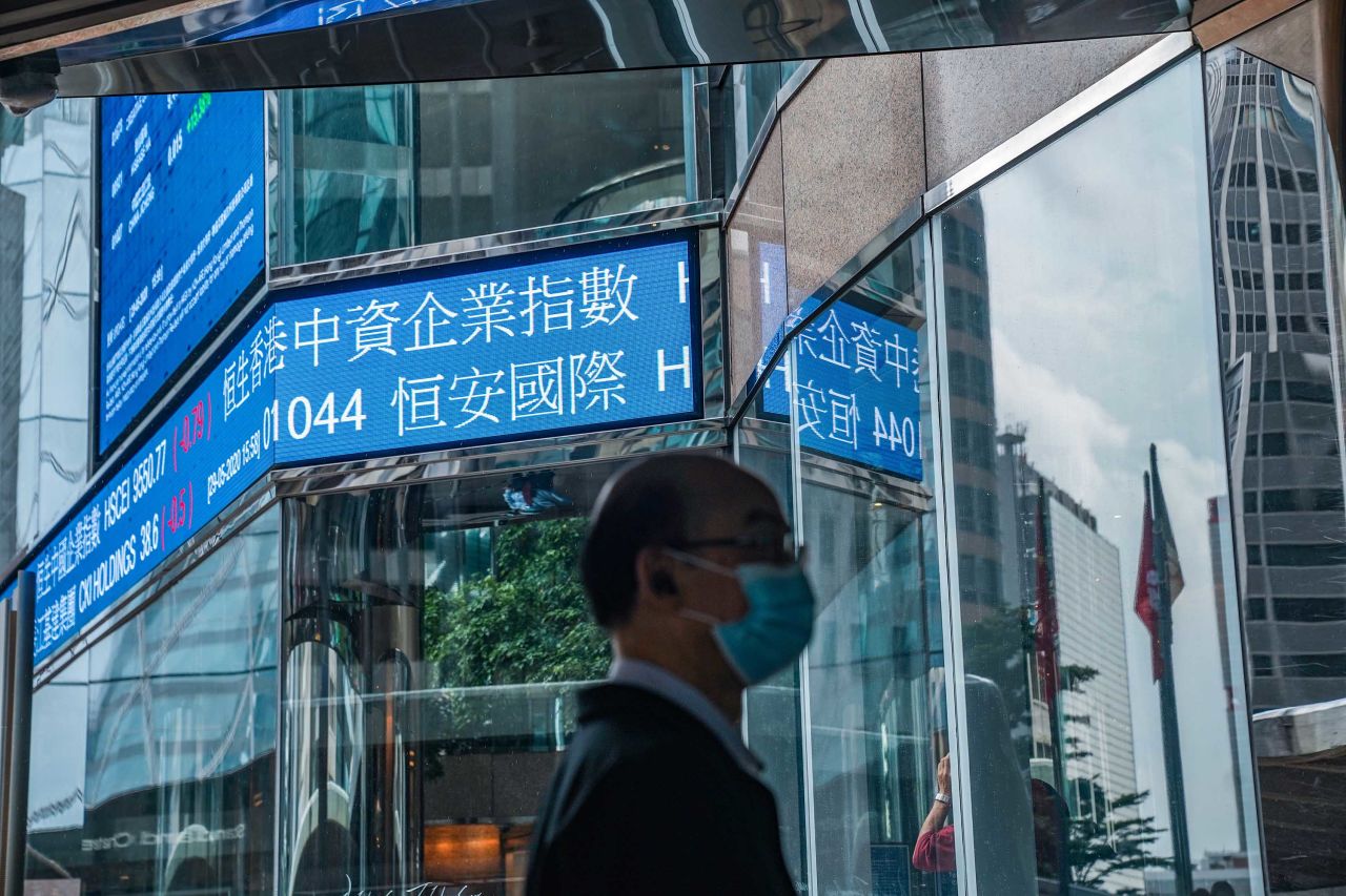 A pedestrian walks past a stock ticker at the Exchange Square complex, which houses the Hong Kong Stock Exchange, in Hong Kong on May 29.