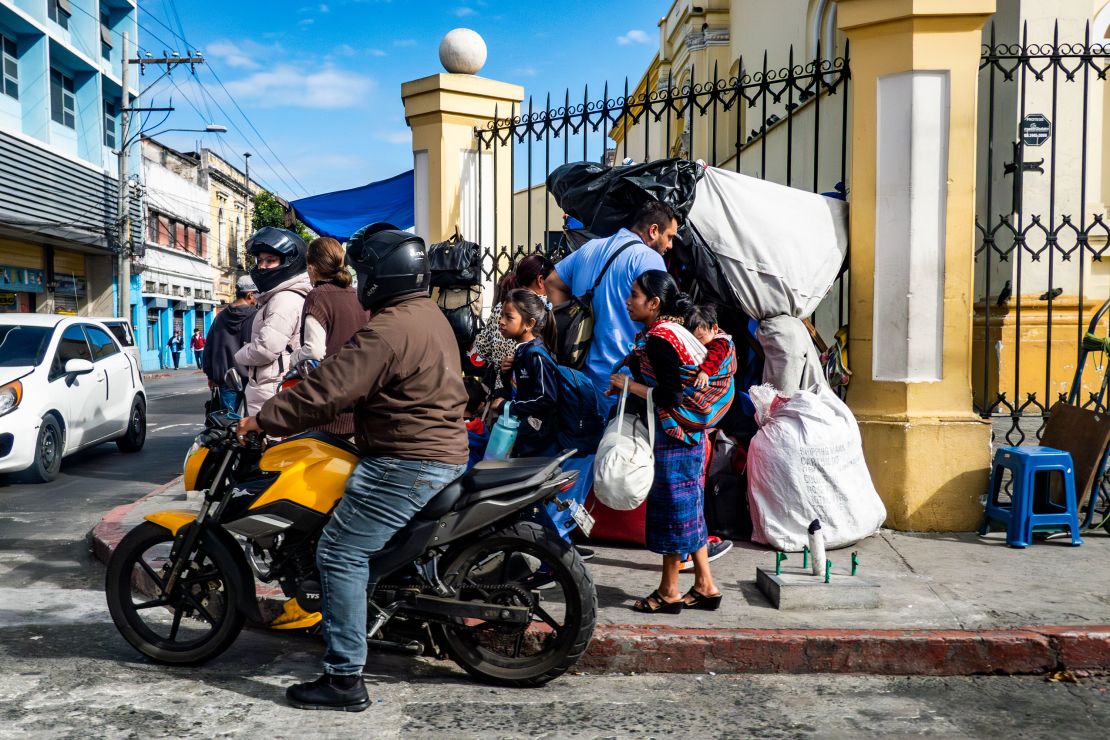 People make their way through Guatemala City on Tuesday.