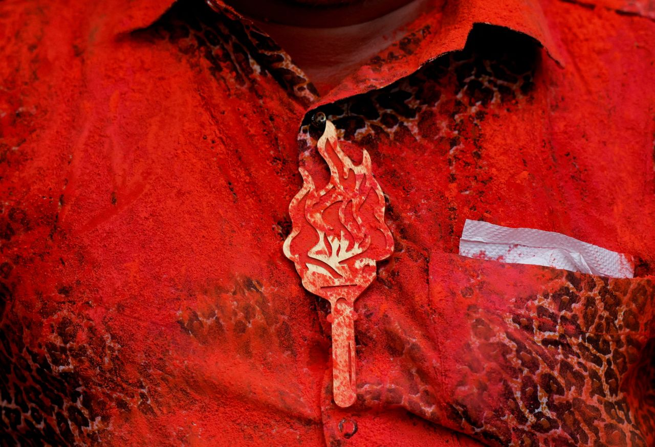 A person wears a badge of Shiv Sena (Uddhav Balasaheb Thackeray) party symbol as it's smeared with color during celebrations at the party office after election results outside the party office in Mumbai on Tuesday.