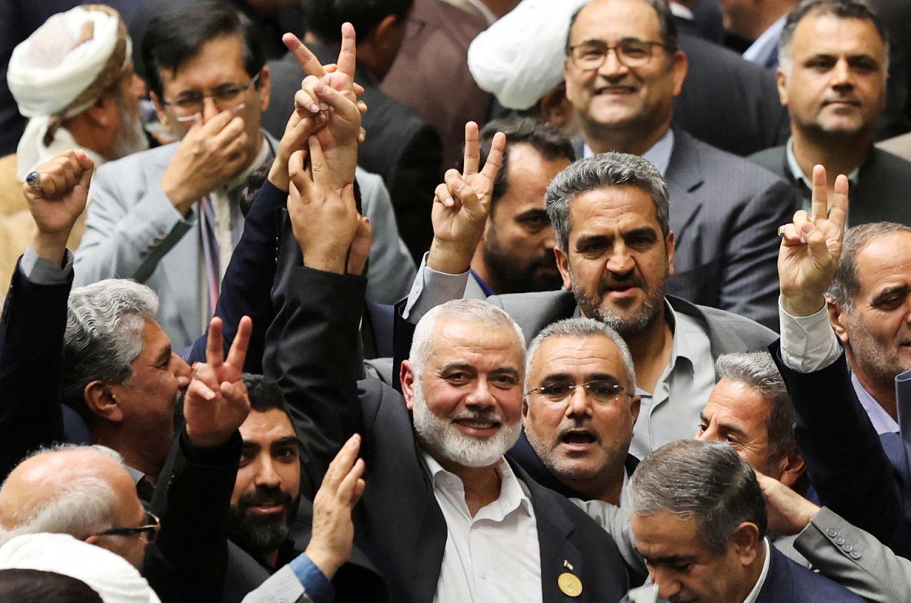 Hamas political leader Ismail Haniyeh, surrounded by lawmakers, flashes a victory sign during the swearing-in ceremony for the new Iranian president at the parliament in Tehran on July 30.