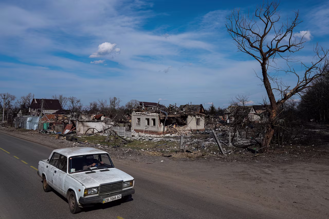 A car moves in a street past damaged houses in Chernihiv, Ukraine, on Thursday, April 7. 