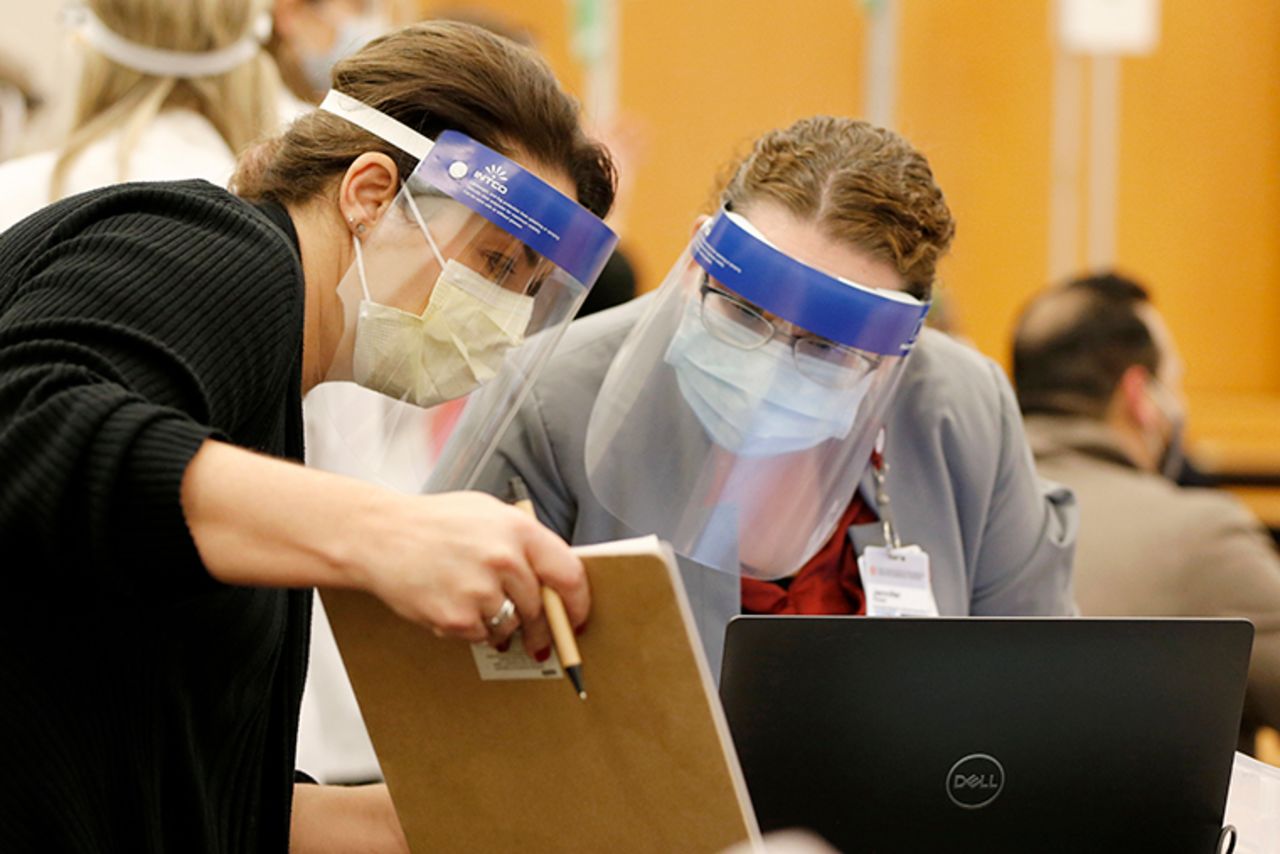 Ohio State employees Kara Scott, left, and Jennifer Rose discuss the new procedures being implemented for the distribution of the Pfizer-BioNTech COVID-19 vaccine Monday, December 14, in Columbus, Ohio. 