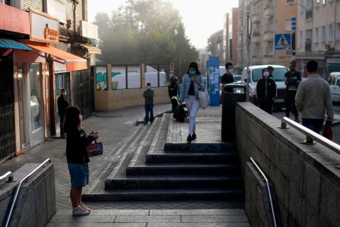 People stand outside a metro station in Madrid early on September 21.
