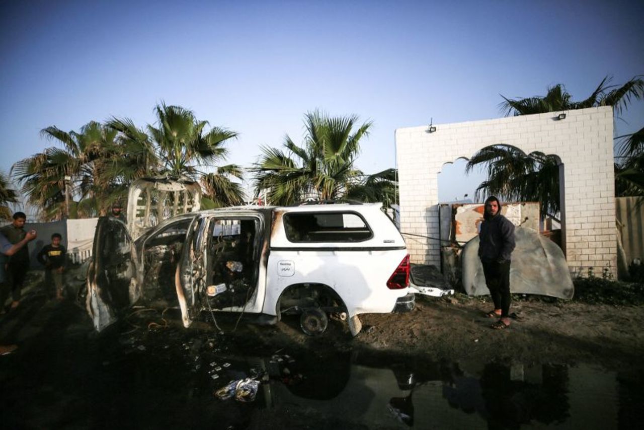 Palestinians stand next to a vehicle in Deir Al-Balah, in central Gaza, on Tuesday, April 2, where employees from the World Central Kitchenwere killed in an Israeli airstrike.