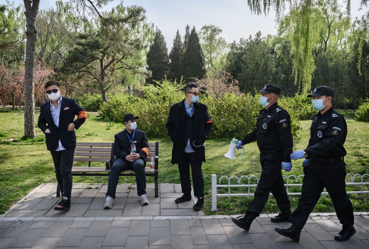 Security guards and park workers wear protective masks on April 5 at a park in Beijing, China. 