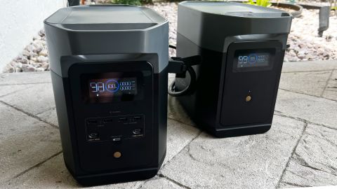 An EcoFlow Delta 2 solar generator with expansion battery, set up on a stone patio