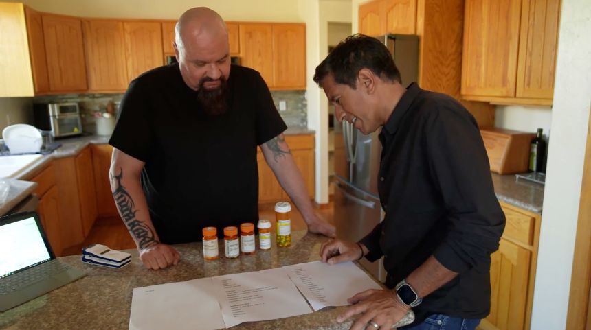 Ed Mowery shows Dr. Sanjay Gupta a list of the numerous medications he used to take. After decades of debilitating pain, Mowery finally found relief from a clinical trial in which electrodes were implanted deep inside his brain to intercept pain signals.