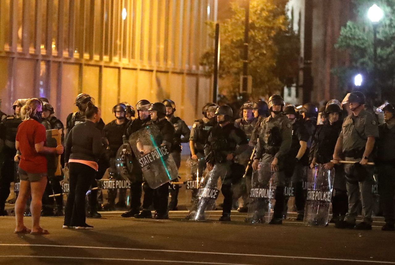 Protesters talk with police officers on Saturday night in Louisville, Kentucky.