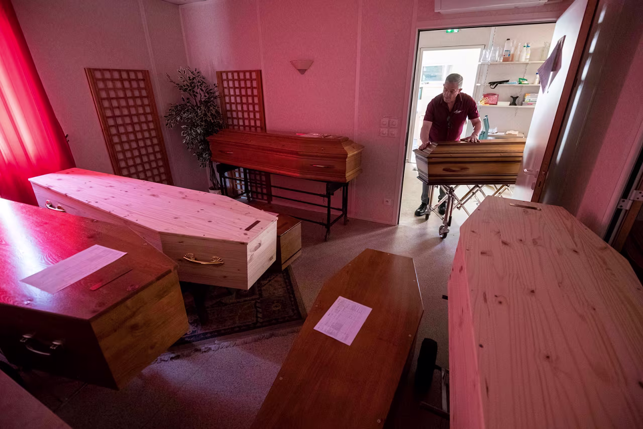 An employee at Lance Funeral Company wheels a coffin of a coronavirus victim into a storage room in Mulhouse, France on April 5.