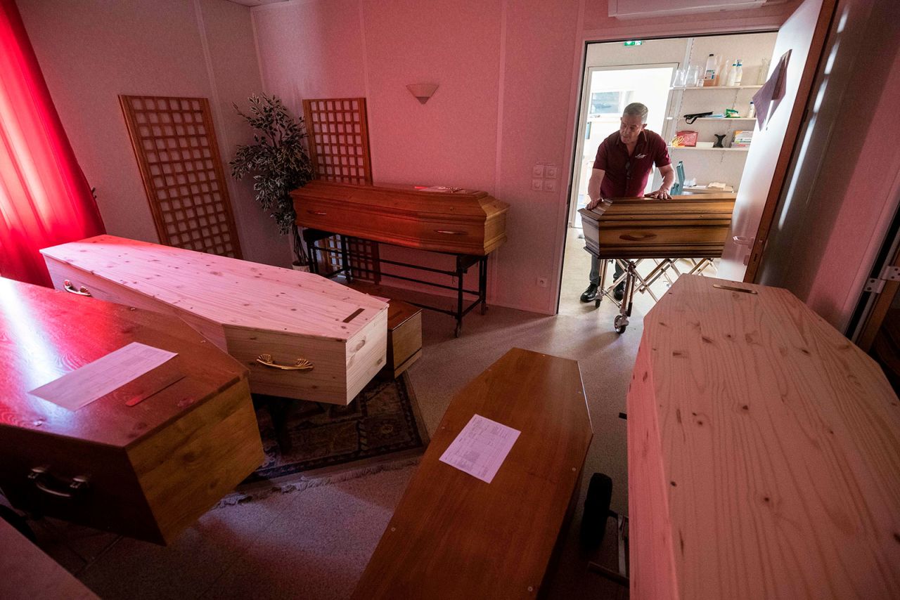 An employee at Lance Funeral Company wheels a coffin of a coronavirus victim into a storage room in Mulhouse, France on April 5.