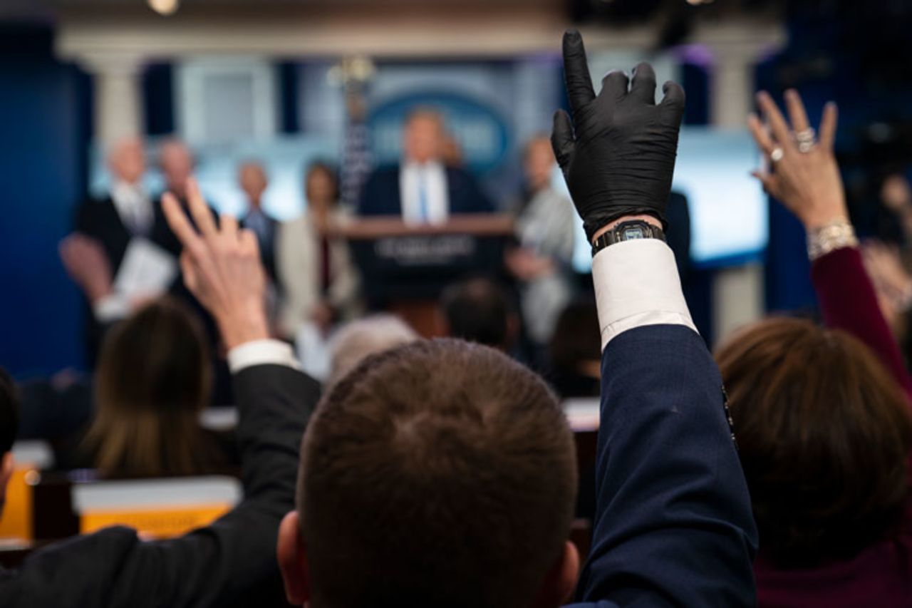 Reporters raise their hands to ask President Donald Trump questions during a news briefing with the coronavirus task force, at the White House, on Monday, March 16, in Washington.