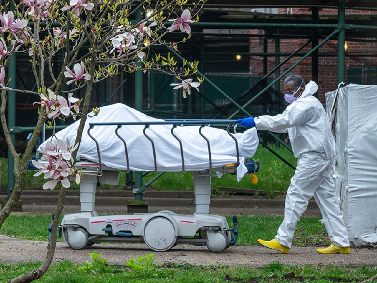A Kingsbrook Jewish Medical Center employee transports a deceased patient to a refrigerated truck on Wednesday, April 8,  in the Brooklyn borough of New York City. 
