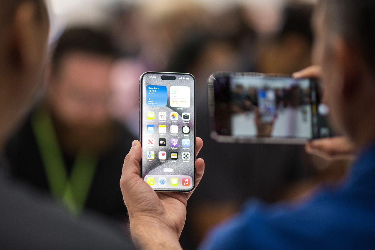 A person looks at an Apple iPhone 15 Pro during a launch event at Apple Park in Cupertino, California, on September 12, 2023.?